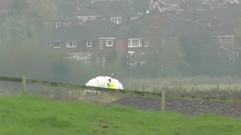 Police tent on the part of a stream a baby's body was found near fields behind houses in Kirkham in 2011. 