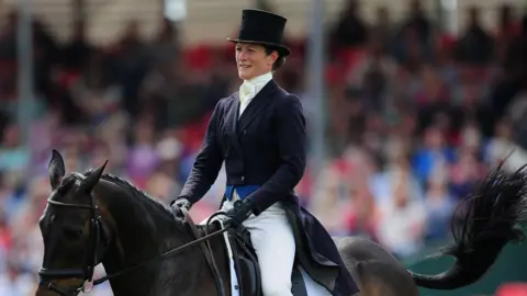 Harry Trump/Getty Images A woman dressed smartly while riding a horse