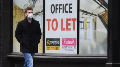 Getty Images A man walks past an office to let sign in London