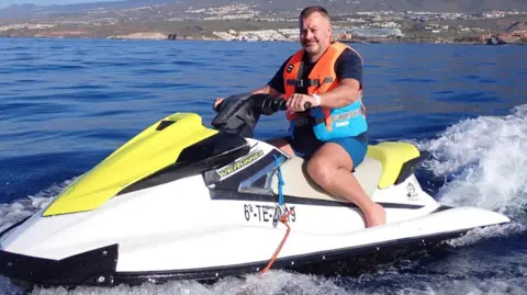 Griffiths driving a jet ski in an exotic location