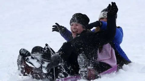 PA Media Two women sledging in Gleneagles