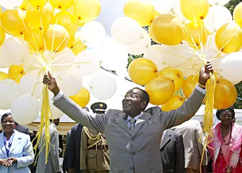 AFP Zimbabwe's veteran leader Robert Mugabe holds 83 balloons in front of relatives and friends at his official residence in Harare, Zimbabwe - 21 February 2007