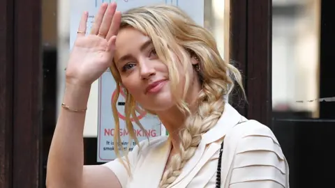 Getty Images US actress Amber Heard waves as she arrives on day 10 of the libel case brought by ex-husband Johnny Depp