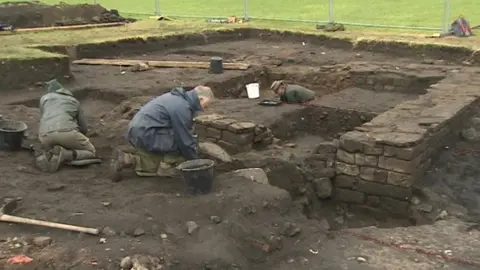 BBC Members of the dig team at work on the site at Birdoswald