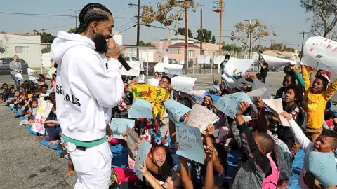 Getty Images Nipsey Hussle speaking to kids