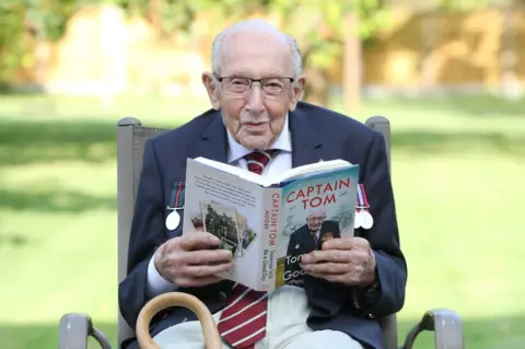 Getty Images Capt Sir Tom Moore reads a copy of his autobiography Tomorrow Will Be A Good Day