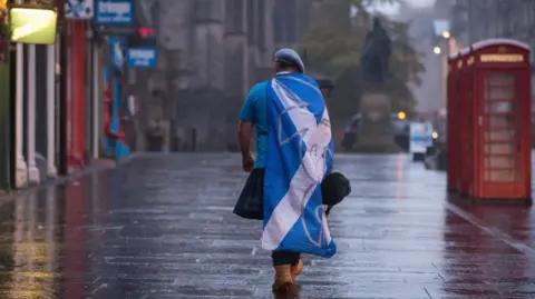 A lone YES campaign supporter walks down a street in Edinburgh after the result of the Scottish independence referendum, Scotland, Friday, Sept. 19, 2014