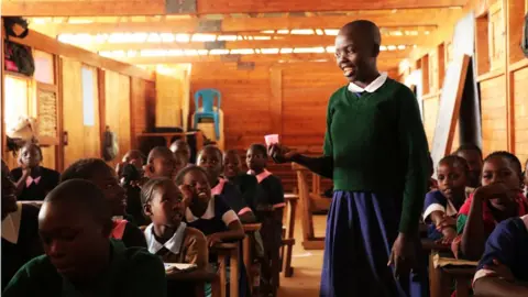 The Ruby Cup  A girl holds up a cup in a class room at one of Ruby Cup's African projects