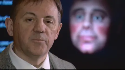 Poet Rab Wilson standing next to the 3D digital model of Robert Burns