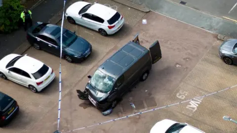 PA Media Police tape around a van on Laing Close in Hainault, east London following reported stabbings and attacks on police officers. A sword-wielding man has been arrested after witnesses spoke of shrieks and screams following reported stabbings and attacks