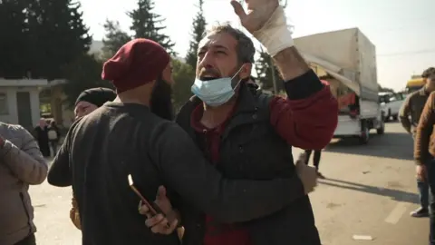 Nouman is held back by Ali at the Bab al-Hawa border crossing