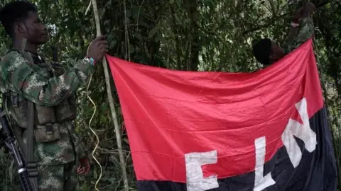 Reuters Rebels of the National Liberation Army (ELN) hold a banner in the north-western jungles in Colombia, August 30, 2017.