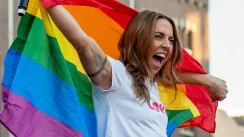 Getty Images Melanie C with a rainbow pride flag on stage in 2018