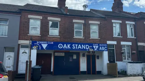 BBC The Oak Stand entrance to Luton Town's front ground which is sandwiched between two terraced houses