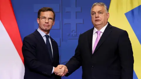 Swedish Prime Minister Ulf Kristersson and Hungarian Prime Minister Viktor Orban shake hands at a joint press conference in Budapest, Hungary, February 23, 2024