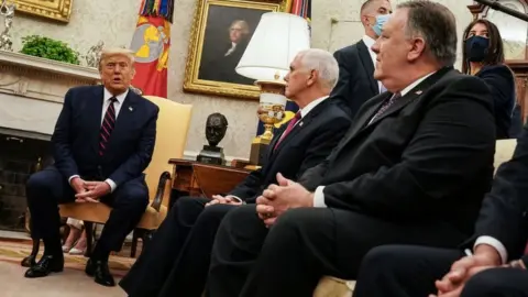 Getty Images File photo showing US President Donald Trump speaking during a meeting with Vice-President Mike Pence (C) and Secretary of State Mike Pompeo (R) in the Oval Office (20 August 2020)