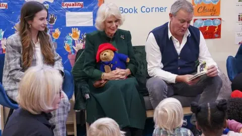 Camilla seated with Paddington film cast members Hugh Bonneville (right) and Madeleine Harris (left)