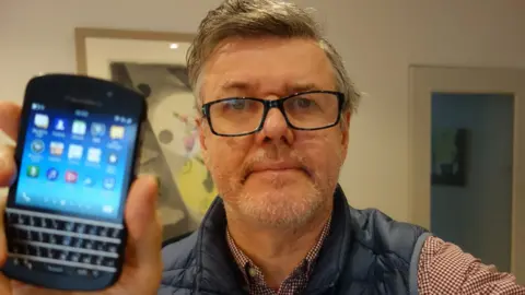 Bill Wilson/BBC The author Bill Wilson holds his beloved Q10