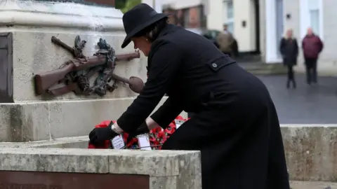PA Media Northern Ireland First Minister Arlene Foster lays a wreath during the Remembrance Sunday service at the Cenotaph in Enniskillen.