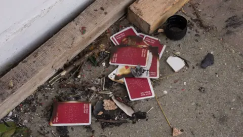 Deborah Norwood Playing cards that had been discarded after someone had tried to set to a board covering a window.