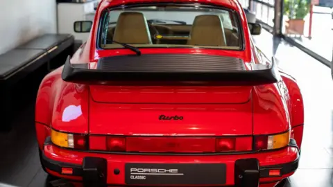 A Porsche 911 Turbo at a Porsche dealership.