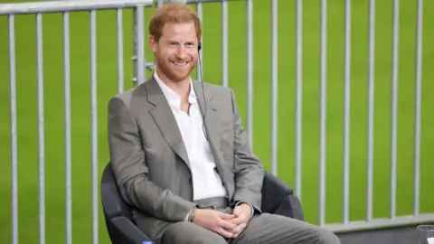 Gety Prince Harry sits on stage