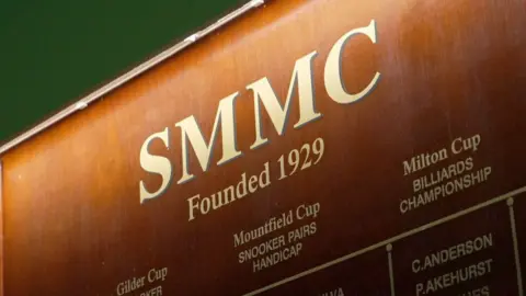 A wooden sign of a snooker club.