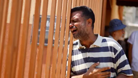 Reuters A man cries during the funeral of a Palestinian reportedly killed in an Israeli strike, at Nasser hospital in Khan Younis, in the southern Gaza Strip (22 July 2024)