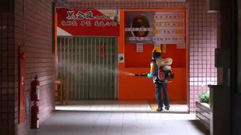 Reuters A worker disinfects a school in Taipei, Taiwan. Photo: 16 May 2021