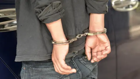 Getty Images Young person in handcuffs