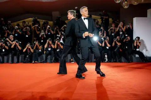 Luca Carlino/NurPhoto/REX/Shutterstock Brad Pitt dan George Clooney berdansa di karpet merah