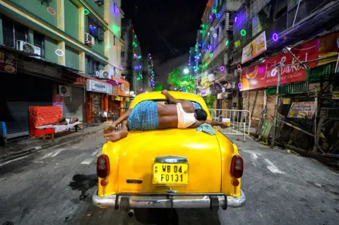 Getty Images Taxi driver asleep in Kolkata