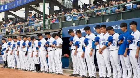 Getty Images Players from Fubon Guardians pay respects for train crash victims in Taiwan, 2 April
