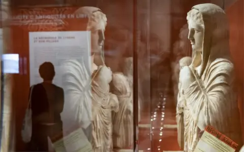 EPA Antique figures on display behind glass.