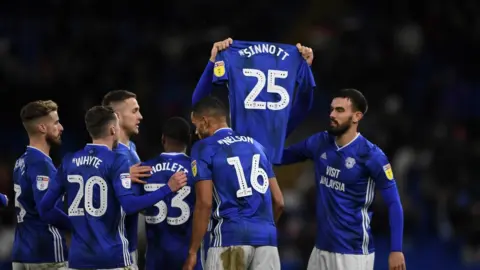 Cardiff City Callum Paterson holds up a shirt with Sinnott on