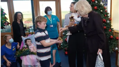 PA Media The Queen handing out gifts to children at the hospice