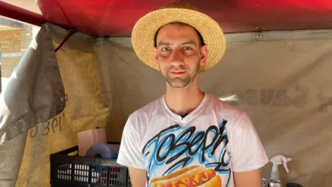 Ben Schofield/BBC Joseph Board, wearing a straw hat, of the Hot Sausage Company