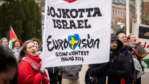 Getty Images Protestors hold a banner criticising Israel's participation in the 2024 Eurovision Context in the host city Malmo on 10 April 2024