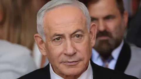 Close up of Benjamin Netanyahu from the shoulders up. He has short, grey hair and is wearing a shirt, tie and suit.