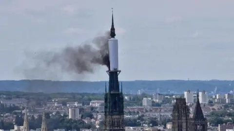 AFP Smoke billows from the spire of Rouen Cathedral in Rouen, northern France.