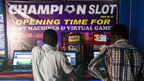 Getty Images Men gambling in betting shop in Uganda