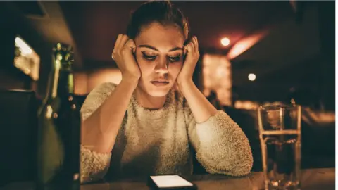 Getty Images Stock image of a woman staring at her phone