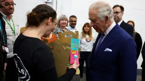 PA Media King Charles with volunteers at the food bank