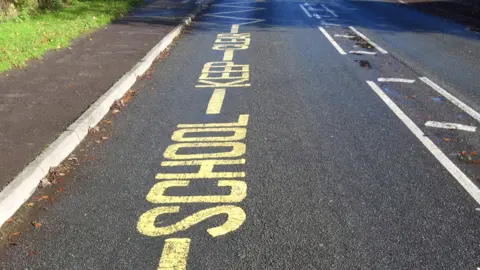 School parking writing and lines on road