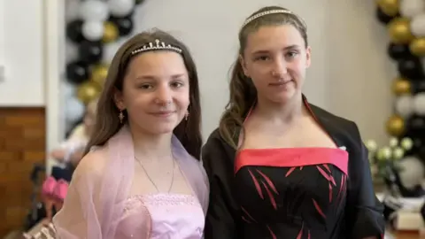 Emma Baugh/BBC Two girls wearing prom dresses they found in 2023