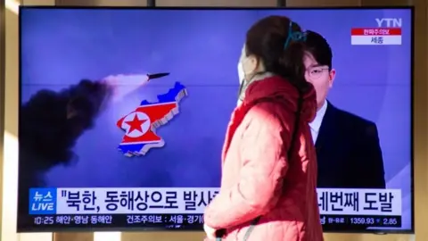 EPA A woman watchs the news at a station in Seoul, South Korea, 17 January 2022.