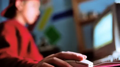 Science Photo Library Boy using computer