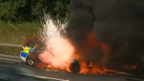 Moment a Devon and Cornwall police car, already on fire, explodes