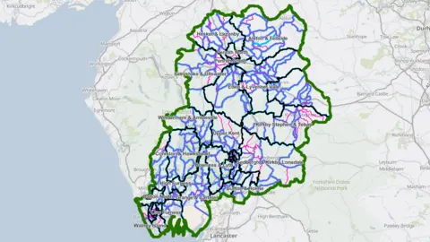 The Local Government Boundary Commission for England A map of with a green line circling the Westmorland and Furness Council area. Dark blue lines indicate the districts within. Purple and pink lines indicate the current and proposed wards. 