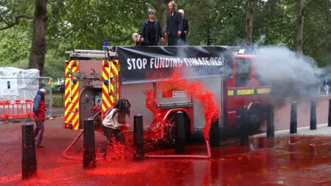 Reuters Extinction Rebellion protesters spray red water at the Treasury